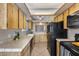 Well-lit kitchen features wooden cabinets, black appliances, and tile countertops at 3339 W Mohawk Ln, Phoenix, AZ 85027
