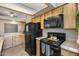 Well-lit kitchen features wooden cabinets, black appliances, and tile countertops at 3339 W Mohawk Ln, Phoenix, AZ 85027
