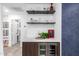 Wet bar showcases a built in wine refrigerator, counter space, overhead shelves, and textured wall at 3619 N 87Th St, Scottsdale, AZ 85251