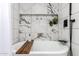 Luxurious bathroom showcasing a soaking tub with marble accents, a built-in shelf, and elegant fixtures at 3619 N 87Th St, Scottsdale, AZ 85251