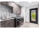 Modern laundry room boasts gray cabinets, tile backsplash, stainless steel appliances, and exterior door at 3619 N 87Th St, Scottsdale, AZ 85251