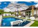 Luxurious pool and patio area featuring modern lounge chairs, outdoor seating beneath a shaded pergola, and lush landscaping at 3619 N 87Th St, Scottsdale, AZ 85251