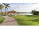 Lakeside park featuring lush green spaces, a picnic pavilion, and a paved walking path by the water at 3830 E Lakewood Pkwy # 2162, Phoenix, AZ 85048
