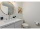 Updated bathroom featuring a modern vanity with a white countertop and a round decorative mirror at 4010 N 156Th Ln, Goodyear, AZ 85395