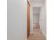 Clean hallway featuring hardwood floors, white walls, and decorative wood cabinets at 4010 N 156Th Ln, Goodyear, AZ 85395