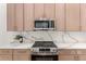 Well-equipped kitchen with sleek stainless steel appliances and complementary quartz countertops at 4010 N 156Th Ln, Goodyear, AZ 85395
