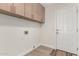 Bright laundry room featuring tile floors, upper cabinets, and white door at 4010 N 156Th Ln, Goodyear, AZ 85395