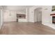 Spacious living room with hardwood floors, a fireplace and an open floor plan leading to the kitchen at 4010 N 156Th Ln, Goodyear, AZ 85395
