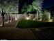 Backyard at night featuring grass, trees, desert landscaping, accent lighting and a brick paver patio at 4433 W Phalen Dr, Phoenix, AZ 85087