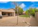 Desert landscaping in backyard with rock, a patch of grass, covered patio and mature trees at 4433 W Phalen Dr, Phoenix, AZ 85087