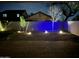 Night view of backyard with desert landscaping and blue accent lights along the block wall at 4433 W Phalen Dr, Phoenix, AZ 85087
