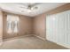 Bedroom featuring plush carpet, a ceiling fan, and a closet with sliding doors at 4433 W Phalen Dr, Phoenix, AZ 85087