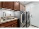 Well-equipped laundry area with modern washer/dryer, granite countertops, and ample cabinet space at 4433 W Phalen Dr, Phoenix, AZ 85087