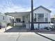 Welcoming manufactured home with covered parking, desert landscaping, and a cozy entrance at 457 S Jaspar Dr, Apache Junction, AZ 85119