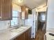 Well-lit kitchen with wood cabinets, white appliances, and a functional layout at 457 S Jaspar Dr, Apache Junction, AZ 85119