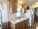 Functional kitchen with a double sink, wood cabinets, and white appliances at 457 S Jaspar Dr, Apache Junction, AZ 85119