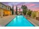 Inviting backyard pool with a stone water feature and a covered patio area with a fire pit under a vibrant sky at 4630 E Hazeltine Way, Chandler, AZ 85249