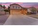 Two story home with a two car garage, landscaped yard, and a stone-accented entryway at 4630 E Hazeltine Way, Chandler, AZ 85249