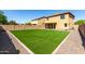 Large backyard featuring an expansive lawn with a covered patio at 4659 E Pinto Valley Rd, San Tan Valley, AZ 85143
