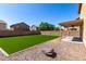 Spacious backyard featuring artificial turf, decorative rock landscaping, and a covered patio at 4659 E Pinto Valley Rd, San Tan Valley, AZ 85143