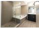Luxurious bathroom showcasing a glass-enclosed shower, soaking tub, and elegant double vanity for a spa-like experience at 4803 N Woodmere Fairway -- # 1003, Scottsdale, AZ 85251