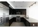 Modern kitchen featuring sleek black cabinetry, stainless steel appliances, and granite counters at 4803 N Woodmere Fairway -- # 1003, Scottsdale, AZ 85251