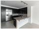 Modern kitchen featuring sleek black cabinetry, stainless steel appliances, and a granite-topped island at 4803 N Woodmere Fairway -- # 1003, Scottsdale, AZ 85251