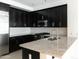 Modern kitchen featuring sleek black cabinetry, stainless steel appliances, and granite counters at 4803 N Woodmere Fairway -- # 1003, Scottsdale, AZ 85251