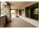 Spacious covered patio featuring stone accents, neutral colors, and an additional storage closet at 4803 N Woodmere Fairway -- # 1003, Scottsdale, AZ 85251