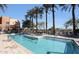 Resort-style pool area featuring tall palm trees, lounge chairs, and clear blue water at The Sage community at 4803 N Woodmere Fairway -- # 1003, Scottsdale, AZ 85251