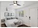 Clean, minimalist bedroom features a large window, ceiling fan, and modern décor at 4907 E Piccadilly Rd, Phoenix, AZ 85018