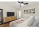 Bright bedroom featuring a ceiling fan, TV, and light wood-style cabinet for storage at 4907 E Piccadilly Rd, Phoenix, AZ 85018