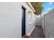 Exterior side view of a white painted brick home with a dark blue door and rock landscaping at 4907 E Piccadilly Rd, Phoenix, AZ 85018