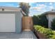 Detached garage featuring a painted brick wall, wooden fence, and a concrete driveway at 4907 E Piccadilly Rd, Phoenix, AZ 85018