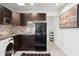 Well-lit kitchenette boasts dark wood cabinets, modern appliances, and an adjacent laundry setup at 4907 E Piccadilly Rd, Phoenix, AZ 85018
