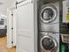 Laundry area with stacked washer and dryer, a sliding barn door and wood look floors at 4907 E Piccadilly Rd, Phoenix, AZ 85018