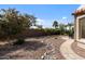 Desert landscaped backyard with lush trees, rock accents and hardscaped area at 4932 S Verbena Ave, Gilbert, AZ 85298