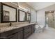 Bathroom featuring double vanity, soaking tub, walk-in shower, and a glass block window at 4932 S Verbena Ave, Gilbert, AZ 85298