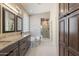 Bathroom featuring a soaking tub, walk-in shower, double vanity with granite counters and linen storage at 4932 S Verbena Ave, Gilbert, AZ 85298
