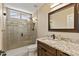 Modern bathroom with a glass-enclosed shower, granite countertop, and framed mirror at 4932 S Verbena Ave, Gilbert, AZ 85298