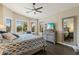 Primary bedroom featuring a bed, nightstands, ceiling fan, dresser with TV, and plantation shutters at 4932 S Verbena Ave, Gilbert, AZ 85298