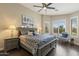 Primary bedroom featuring a large bed, nightstands, ceiling fan, and plantation shutters at 4932 S Verbena Ave, Gilbert, AZ 85298