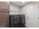 Convenient laundry room featuring side by side washer and dryer and wall art at 4932 S Verbena Ave, Gilbert, AZ 85298