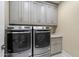 Convenient laundry room with gray cabinetry, granite counters, and modern washer and dryer at 5250 E Deer Valley Dr # 206, Phoenix, AZ 85054