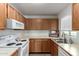 Functional kitchen with white countertops, wood cabinets, and essential appliances at 5518 E Lindstrom Ln # 3012, Mesa, AZ 85215