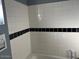Clean bathroom with white tiles and a black accent stripe at 637 E Kramer St, Mesa, AZ 85203