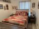 Inviting bedroom with a patterned quilt, side tables, and decorative wall art at 637 E Kramer St, Mesa, AZ 85203