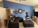 Inviting living room features a large leather sectional sofa with a decorative clock arrangement on the wall at 637 E Kramer St, Mesa, AZ 85203