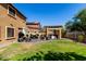 Spacious backyard featuring a well-maintained lawn, shaded patio with outdoor kitchen, and seating area at 7359 W Kings Ave, Peoria, AZ 85382