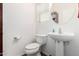 Powder room featuring a sleek pedestal sink, toilet, and neutral finishes at 7359 W Kings Ave, Peoria, AZ 85382